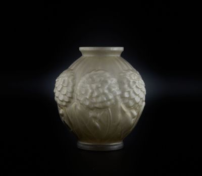 un vase blanc orné d'un visage, posé sur une table