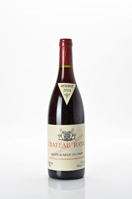 une bouteille de vin de Château Rayne posée sur une surface blanche