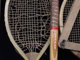 three wooden tennis rackets are lined up against a black background