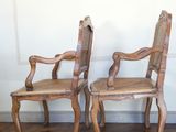 two wooden chairs sitting next to each other on a hard wood floor