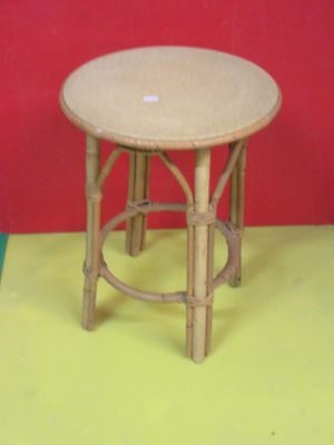 une petite table en bois avec un plateau rond posée sur un sol jaune