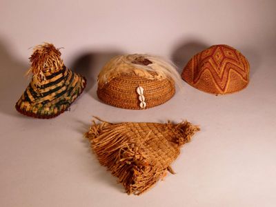 three hats and a bag are sitting on a white surface