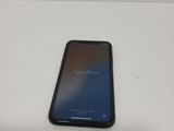 the back of a black phone sitting on top of a white table