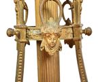 a gold clock on a stand with a face on it