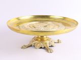 assiette en or ornée d'une tête de lion, posée sur un socle