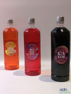 trois bouteilles de boissons aux saveurs différentes posées sur une surface blanche
