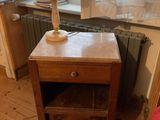 a small table with a lamp on it in front of a window