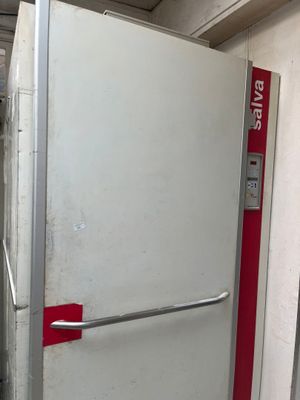 un réfrigérateur blanc muni d'une poignée rouge dans une pièce