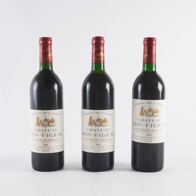 trois bouteilles de vin sont alignées sur une surface blanche