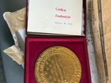 une image représentant une médaille d'or dans un coffret rouge posé sur une table