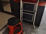 un tabouret rouge et une chaise noire et blanche dans une pièce