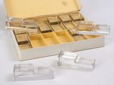 a silver box filled with clear plastic containers on a white surface