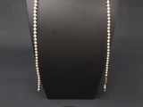 un ensemble composé d'un collier et de boucles d'oreilles en perles, présenté sur un mannequin