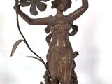 bronze statue of a woman holding a flower in her hand