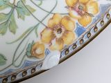 a close up of a vase with yellow flowers on it
