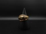 gros plan d'une bague en or sur une surface noire