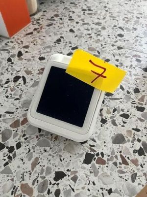 a small white box with a yellow sticker on top of it