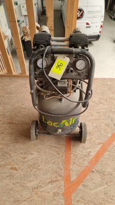 a small air compressor sitting on the floor in the garage