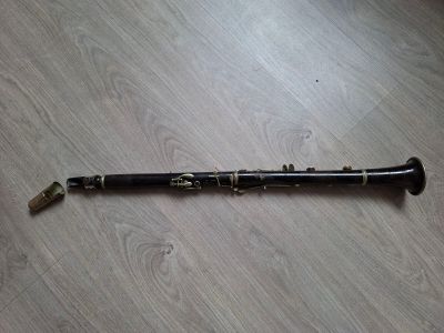 un instrument noir et doré posé sur un parquet