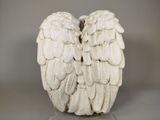 a white sculpture of an angel wings on a table