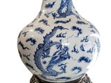 a blue and white vase on a stand with a dragon on it
