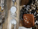 a glass bottle filled with jewelry on a table
