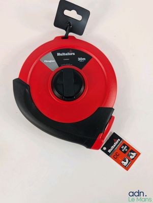 un gros plan d'un mètre ruban rouge posé sur une surface blanche