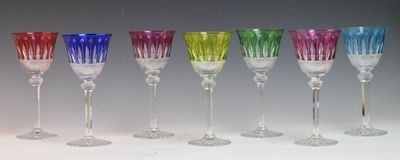 six different colored wine glasses are lined up in a row