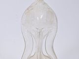 a clear glass bottle with a handle on a white surface