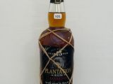 un gros plan sur une bouteille de rhum Plantation posée sur une table