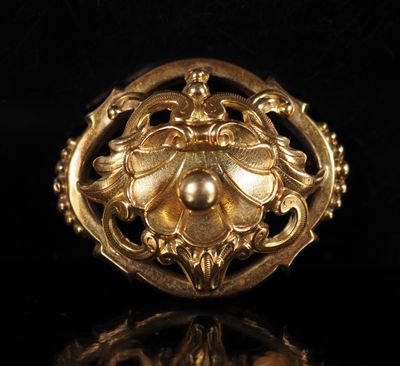 gros plan d'une bague en or avec une perle au centre
