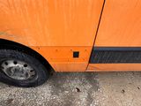 a close up of an orange bus parked on the side of the road