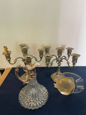 a silver candelab and a glass cup on a table