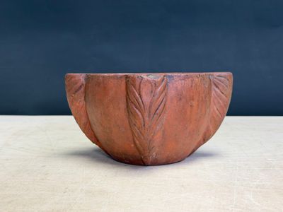 une image représentant un bol rouge posé sur une table en bois