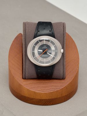 a watch sitting on a wooden stand on a table