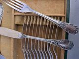several forks and spoons are arranged in a box with a knife and fork