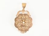 Gros plan sur un pendentif en or orné d'un motif floral