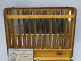 six knives in a case with a card in it