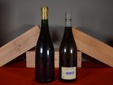 two bottles of wine sitting next to each other on a table