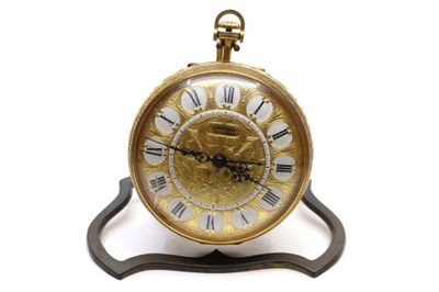 une horloge dorée à chiffres romains posée sur un socle