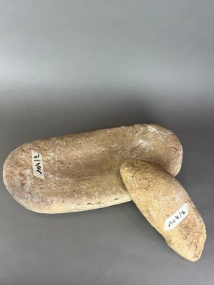 une paire de pantoufles en pierre posées l'une sur l'autre sur une surface grise