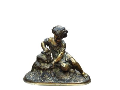 une statue de femme assise sur un rocher avec un chien