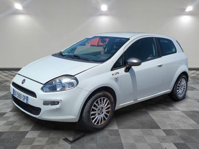 la petite voiture blanche est garée sur un sol en damier