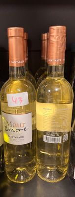 plusieurs bouteilles de vin sont alignées sur une étagère dans un magasin