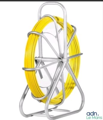 un gros plan d'une bobine de fil jaune posée sur un support métallique
