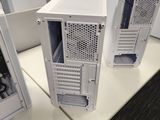 several white computer cases are lined up on a white table