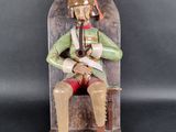 statue of a man sitting on a chair with a pipe in his hand