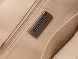 the back of a beige purse with a black label on it