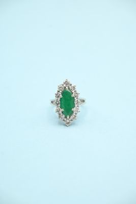 a close up of a ring with a green stone in it