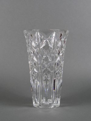 un gros plan d'un vase en verre posé sur une surface grise